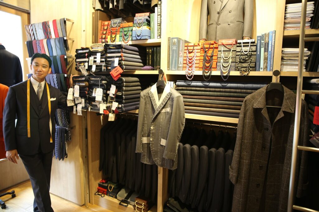 生地とスーツが並ぶ TAILOR Blades の店内と店主